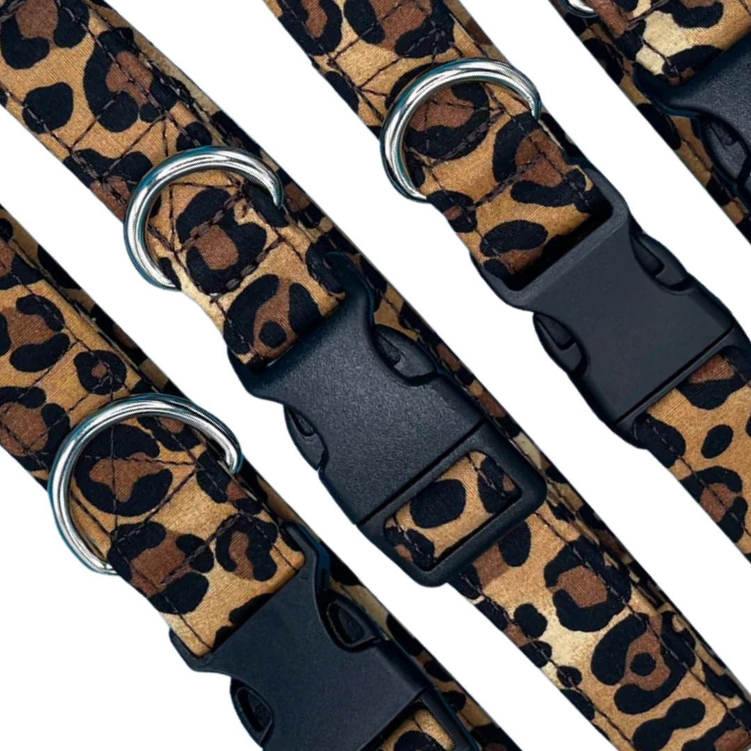 A close up of adjustable brown and black animal print dog collars with metal D rings and plastic buckles.