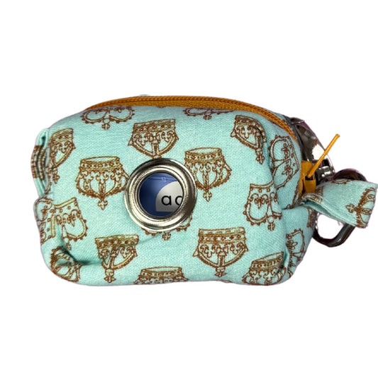 Side view of a light blue poo bag holder pouch with a crowns pattern and gold zipper.