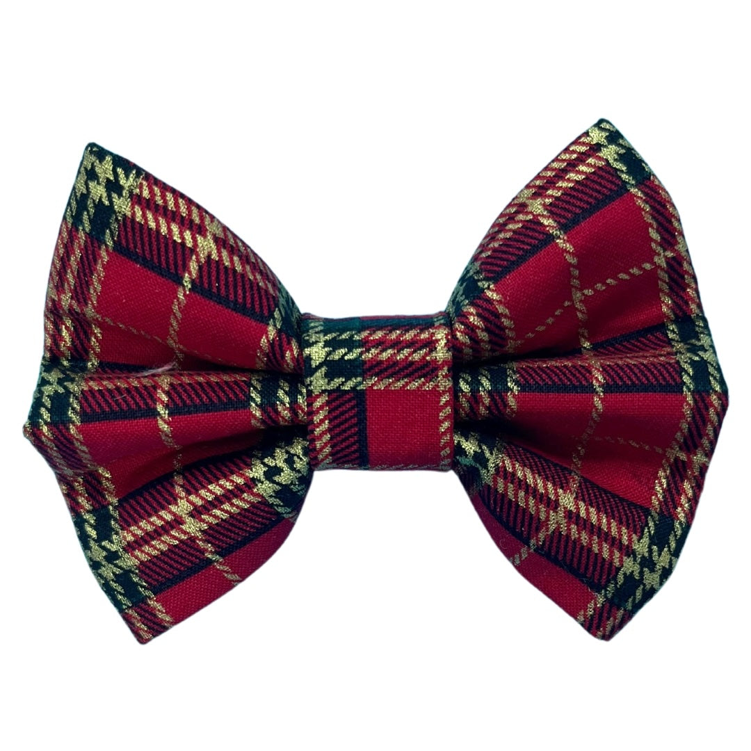 A red tartan dog bow tie with a plaid black and gold pattern