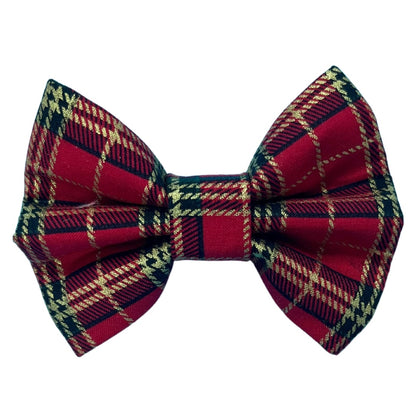 A red tartan dog bow tie with a plaid black and gold pattern